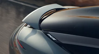 Detalle de la parte trasera del Peugeot RCZ Vision gris azulado, con alerón elevado, techo oscuro y firma luminosa roja.