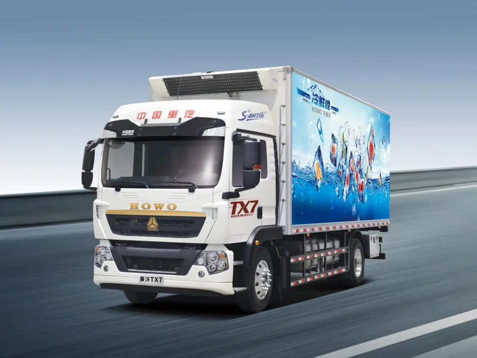 Camión frigorífico blanco Sinotruk HOWO TX7 circulando por una carretera, con unidad refrigeradora sobre la cabina y peces de colores en la caja lateral.