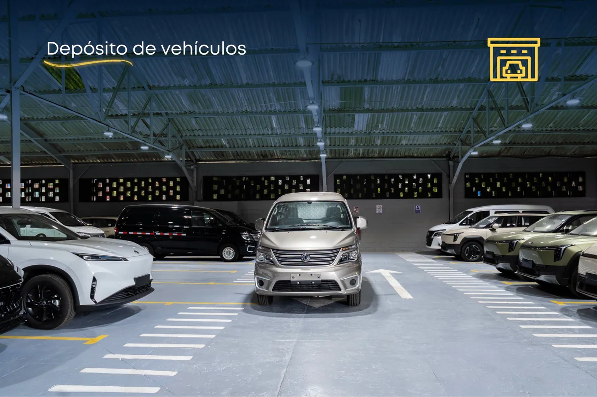 Interior del depósito de vehículos del complejo automotriz Dongfeng en La Habana, con automóviles y furgonetas estacionados.