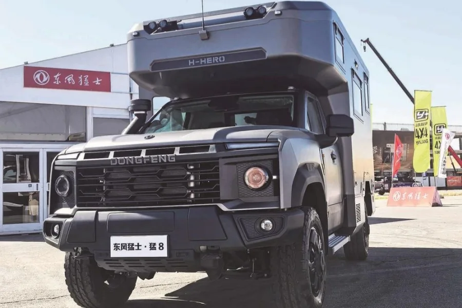 Vista frontal de un Dongfeng Mengshi Meng 8 gris con módulo habitable elevado, expuesto en una muestra de vehículos todoterreno.