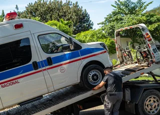 Operario junto a una ambulancia durante su carga en una grúa de plataforma en La Habana.